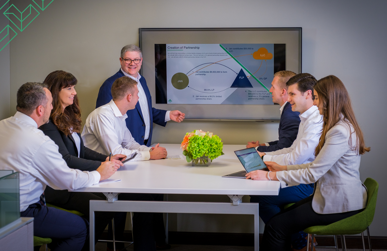 Financial Advisors sitting around a table serving as an image for Joe Abellard's Client Portfolio Bio page